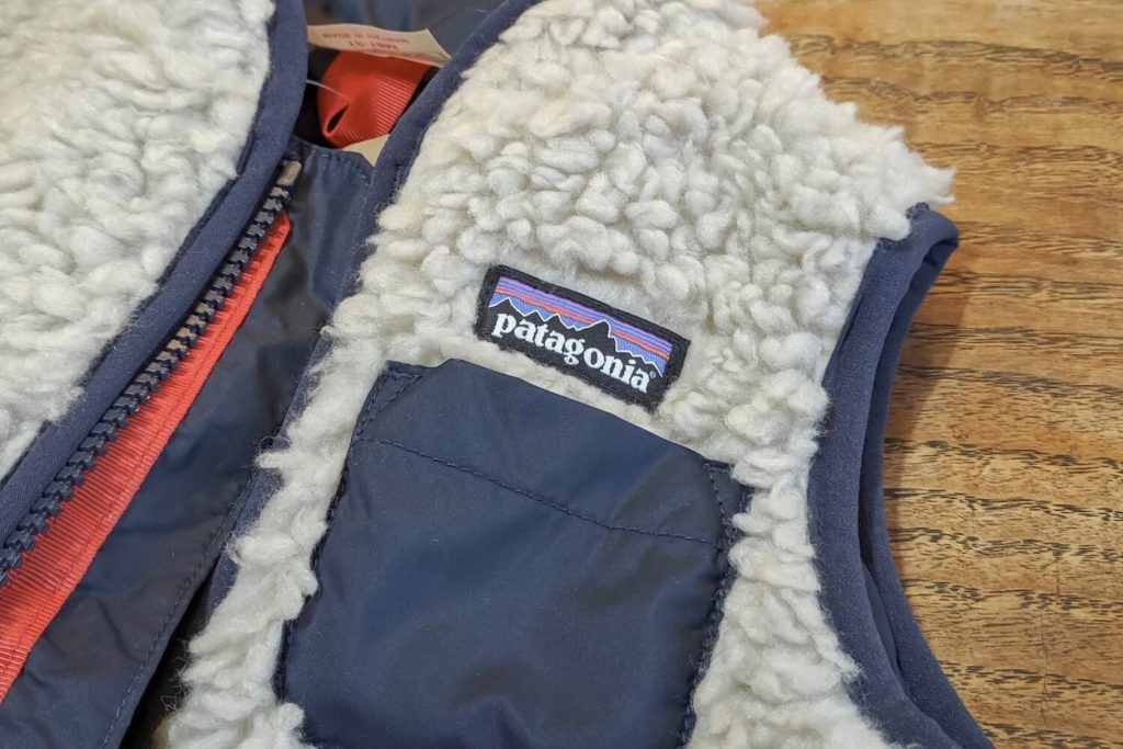 当時のベストの胸元ポケット、Patagoniaのロゴと赤いジッパー